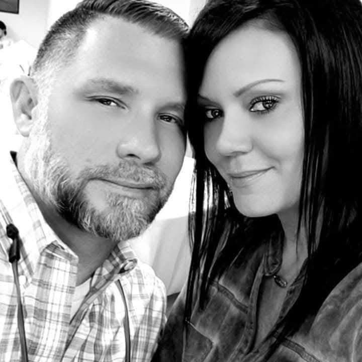 A friendly husband and wife team installing holiday string lights on a residential home in Pinehurst, TX